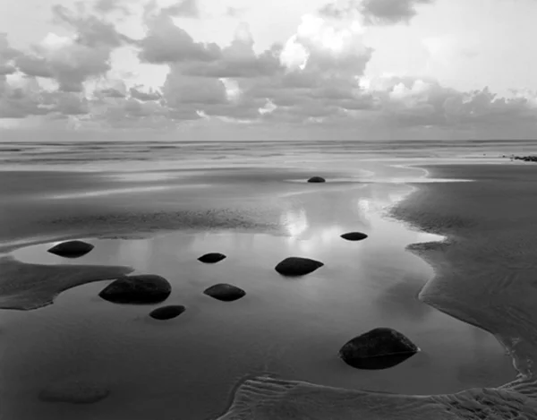 low tide beach with stones puddles