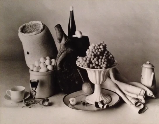 Still life of grapes in raised bowl tea cup pot napkin