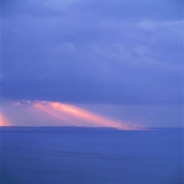 blue seascape dramatic pink light beams sky