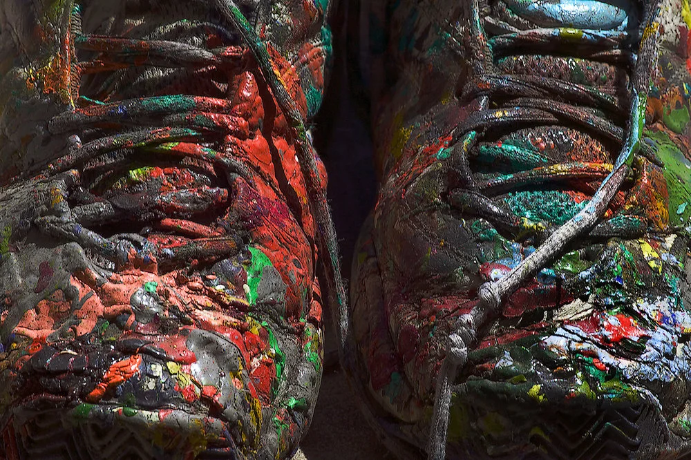 close up multi color paint splotched sneakers