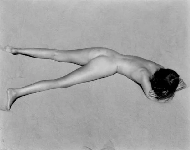 nude woman laying in sand