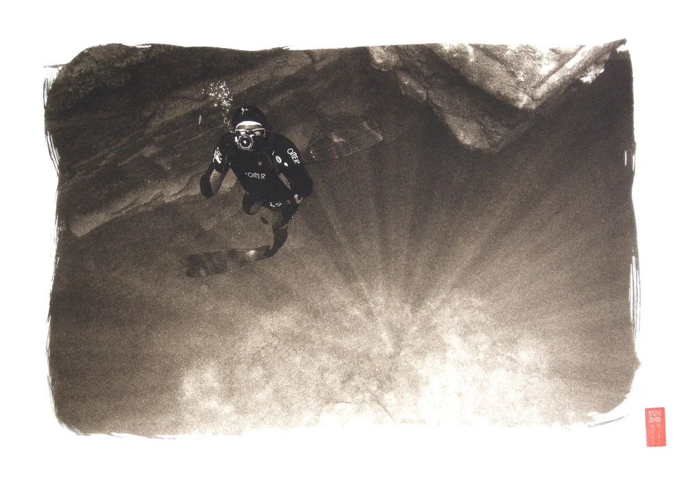 diver from above with camera bubbles light beams