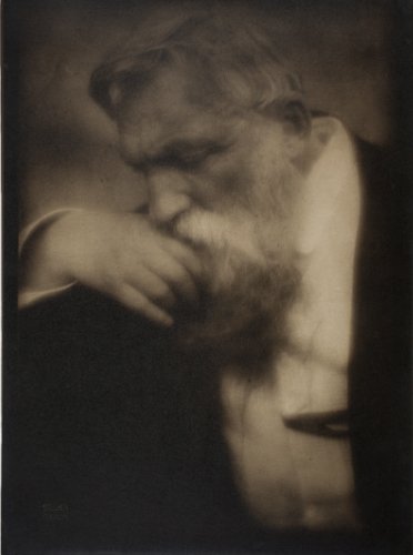 man beard rodin thinking looking down white shirt dark blazer hand on chin