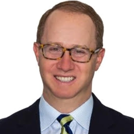 Paul Lemming in a suit in front of a white background.