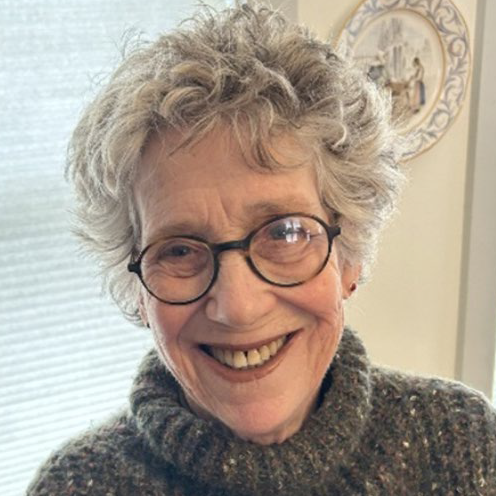 Picture of Pam Lemming with a grey sweater and in front of a beige background.