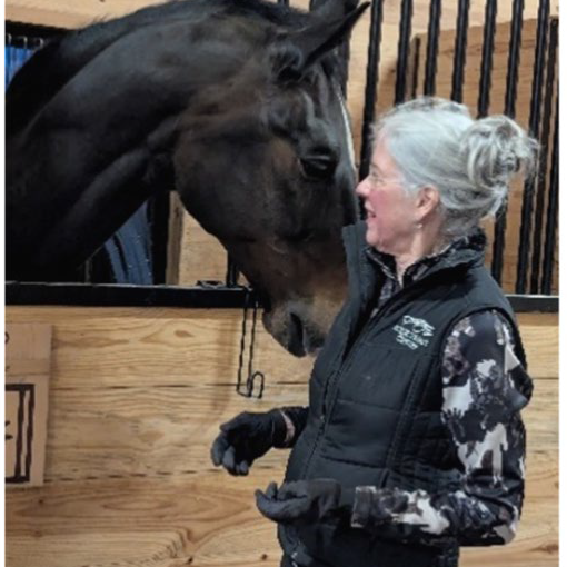 Picture of Jean Marquand in a barn with a horse.
