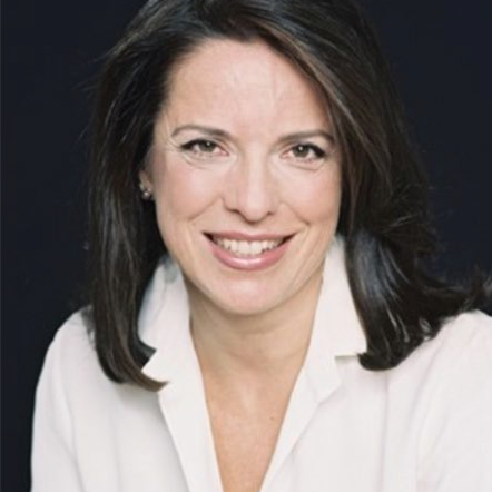Terri Brennan in a white shirt against a black background.