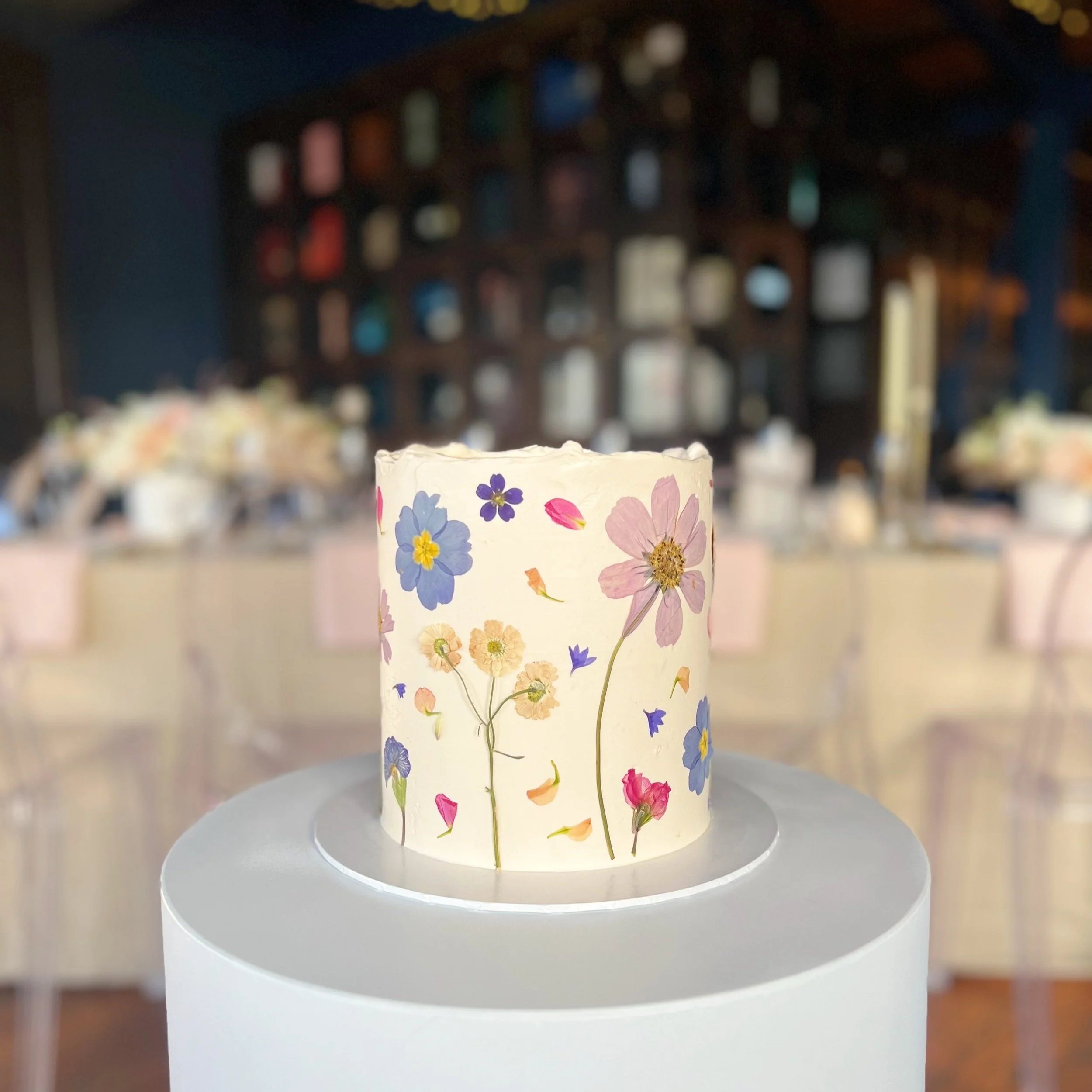 white swiss meringue buttercream tall cake colourful pressed flowers