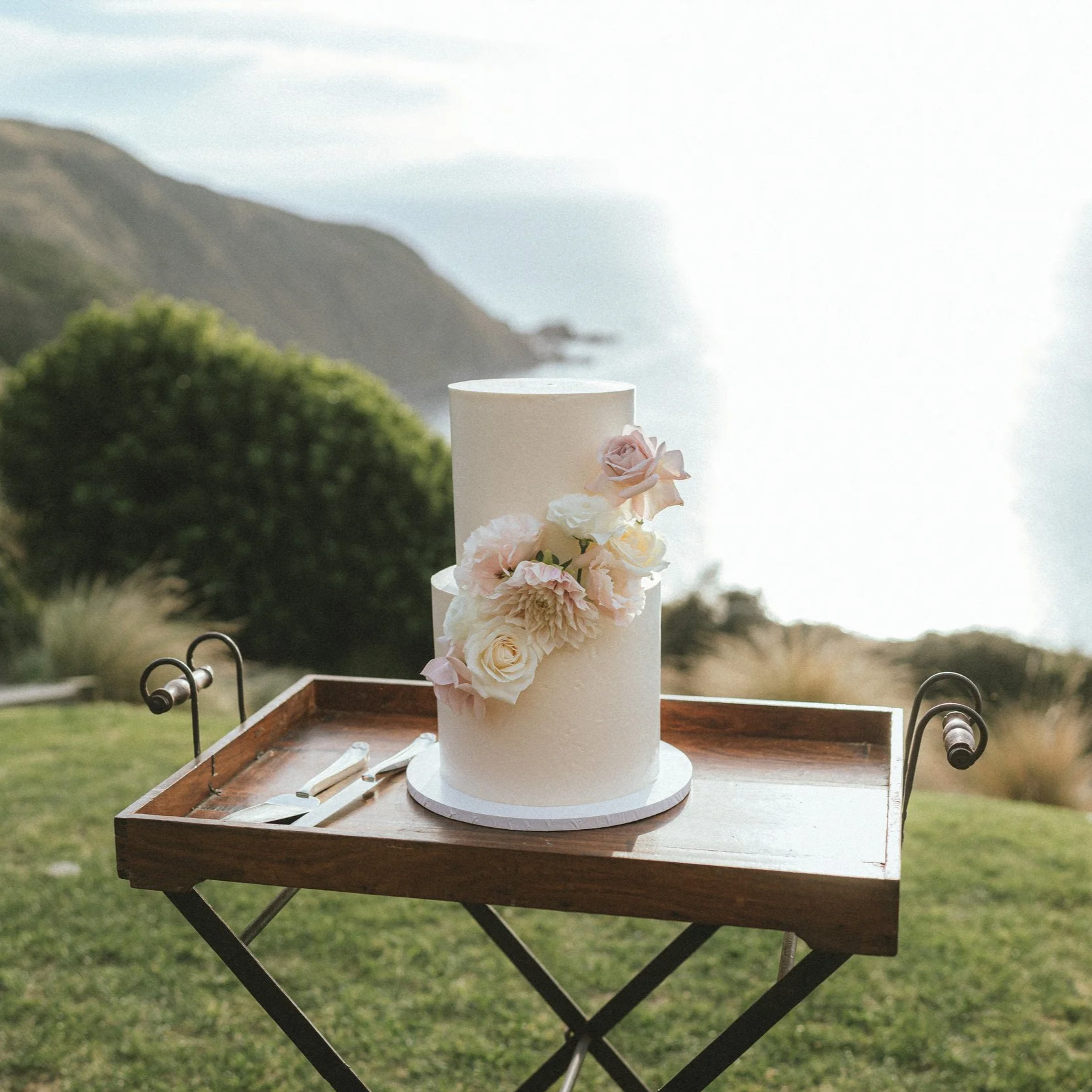 two tier white wedding cake summer flowers