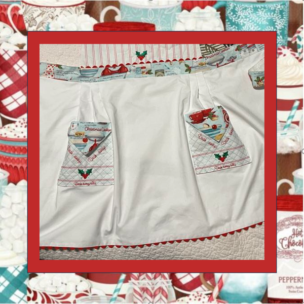 Retro Christmas In the Hoop apron skirt closeup with embroidered bib panels, rick rack accents, holly motifs, vintage cookie cutter designs, and holiday text.