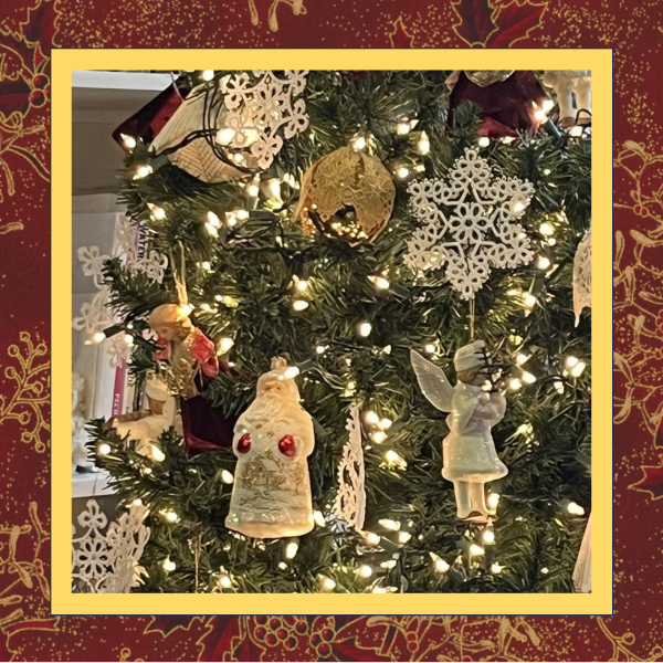 A delicate tatted free-standing lace star snowflake ornament, stitched in white thread and displayed as a Christmas decoration.