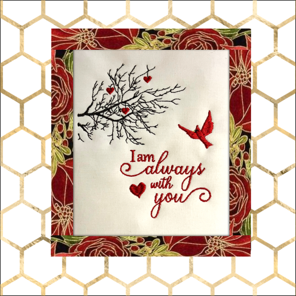 Machine embroidery wall hanging with cardinal bird, tree branches, small hearts, and the phrase “I am always with you” in red script on a neutral fabric background with decorative border