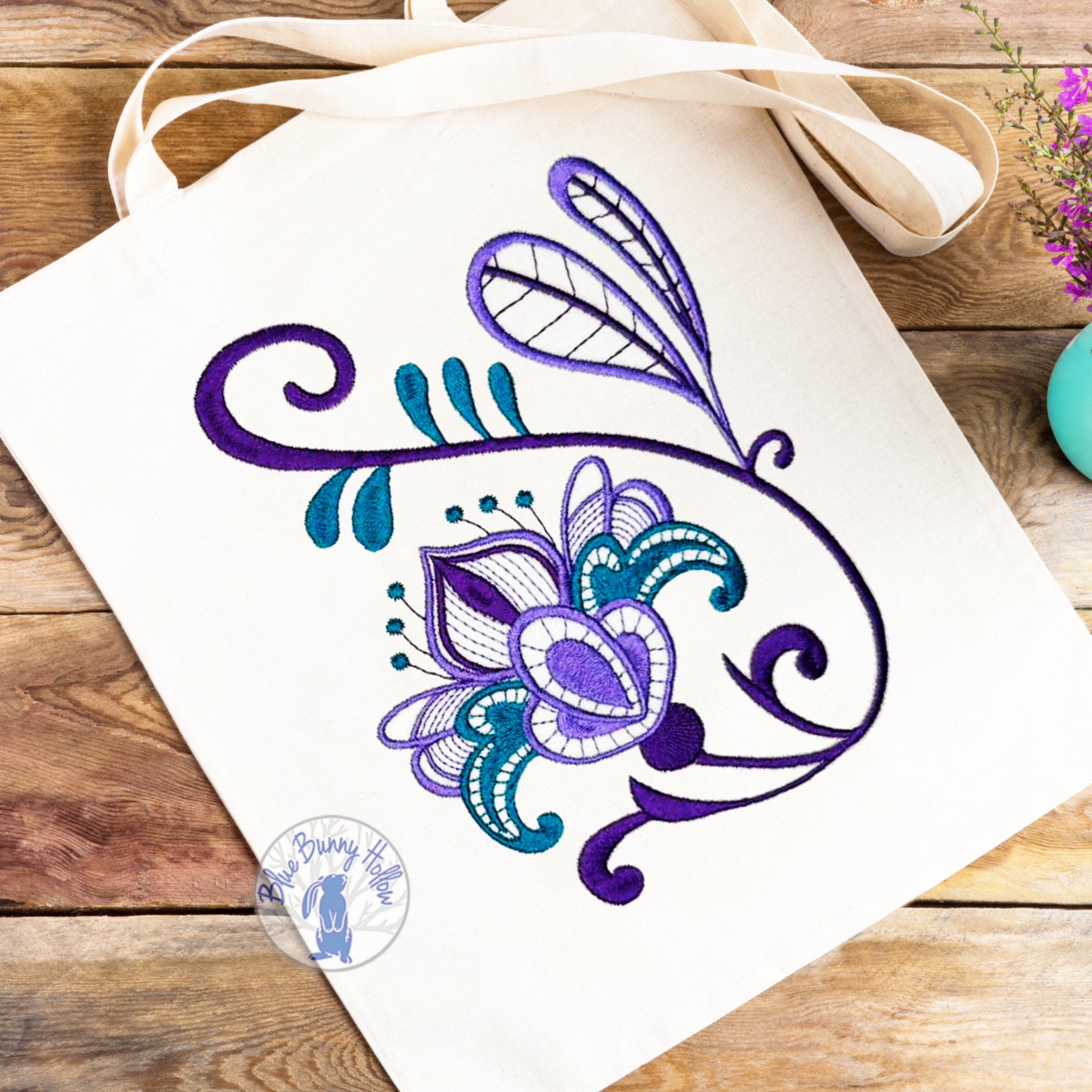Elegant floral embroidery design with lavender wildflowers and teal accents.