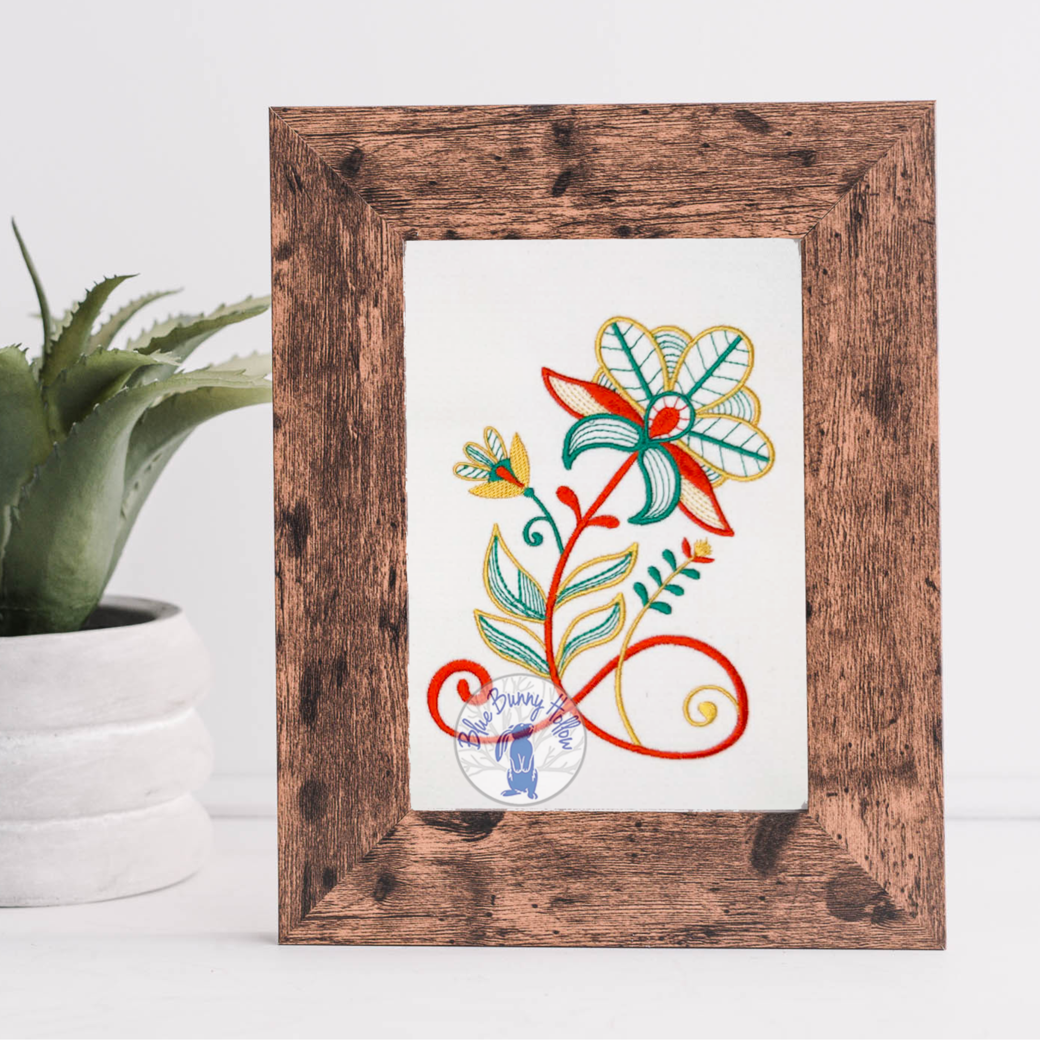 Beautiful Wild Blossoms embroidery design stitched in red and teal thread on fabric.