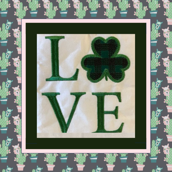Machine embroidered mugrug featuring the word LOVE with a plaid stitched applique shamrock on a quilted background.