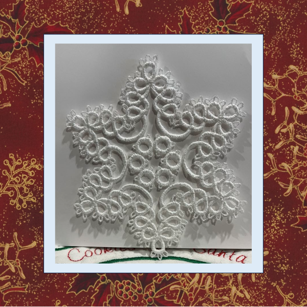 A delicate tatted free-standing lace star snowflake ornament, stitched in one color for Christmas or winter decoration.