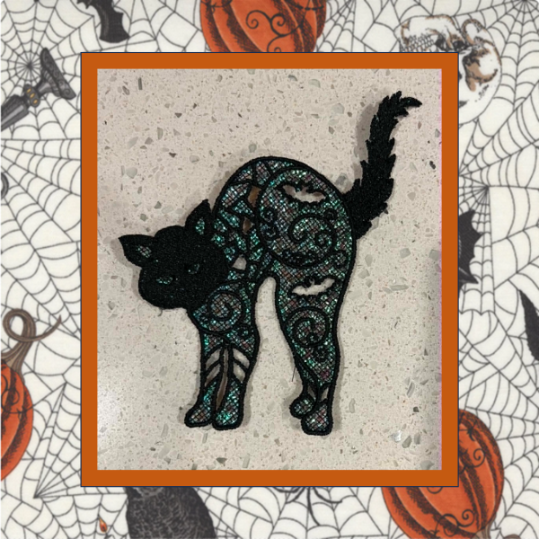 Glittery Mylar lace cat Halloween ornament machine embroidery design with curled tail and intricate black stitching.