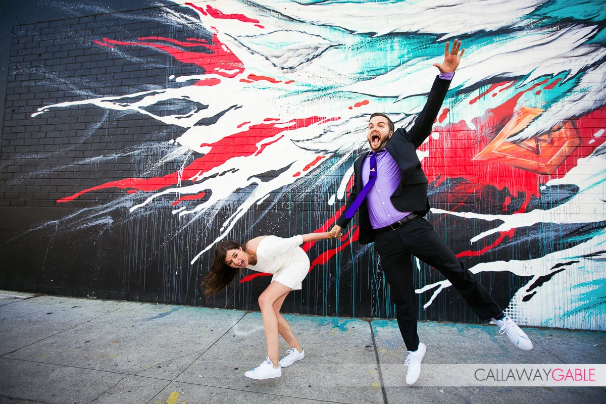 hilarious engagement photo in front of street art wall in downtown Los Angeles