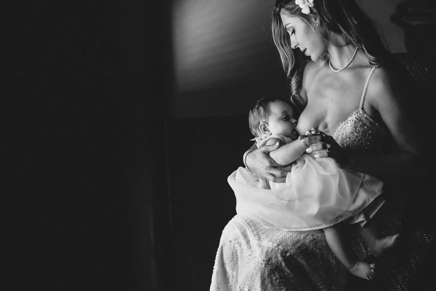 Initimate black and white photo of Breastfeeding Bride