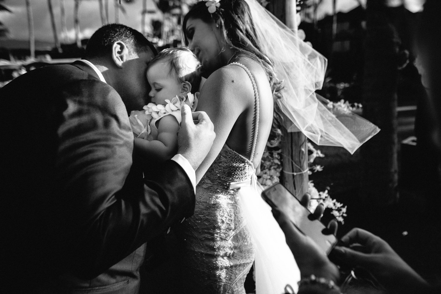 with their baby, Ben and Orian have a kiss under the chuppah by Big Island Wedding Photographer Callaway Gable