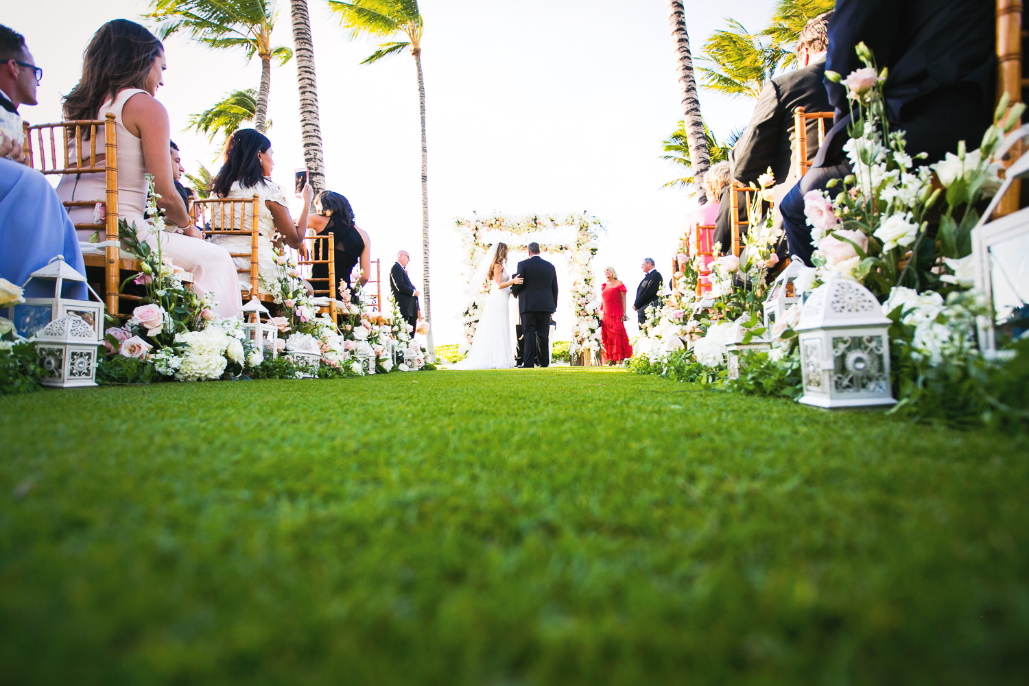 Great low shot in the grass wedding ceremony on the beach at the Four Seasons Hualalai