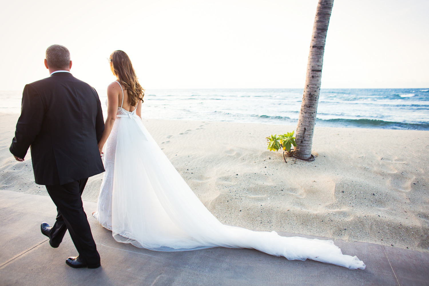 Walking towards the sunset as newlyweds at the Four Seasons Hualalai by Big Island wedding photographer Callaway Gable