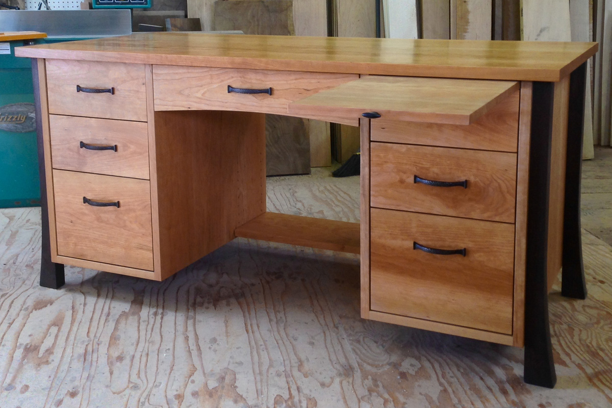 Cherry desk with walnut legs, pencil drawer, two lower file drawers, and pull out writing surface.