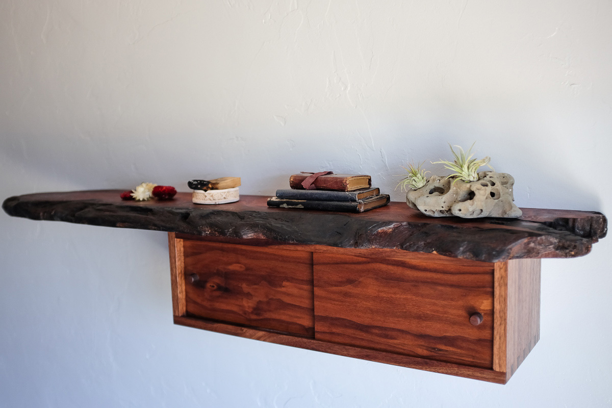 Salvaged redwood hanging shelf with dovetail walnut box featuring sliding pocket doors. The redwood live edge of the redwood tells of fire, I retained the blackened edge.