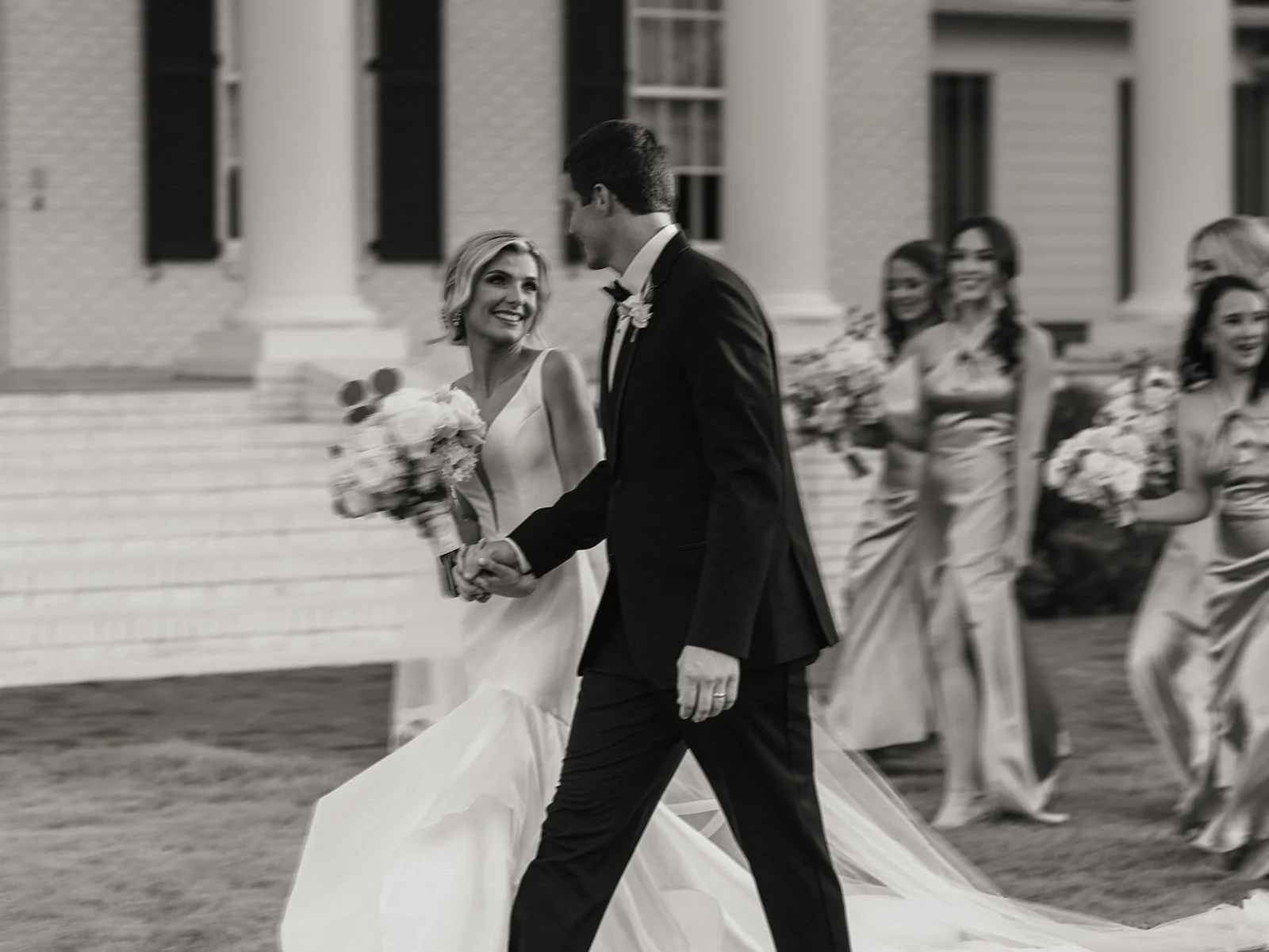 black and white photo of bride and groom walking