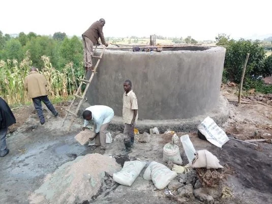 A community rain water harvesting water tank under construction in Nzogera village
