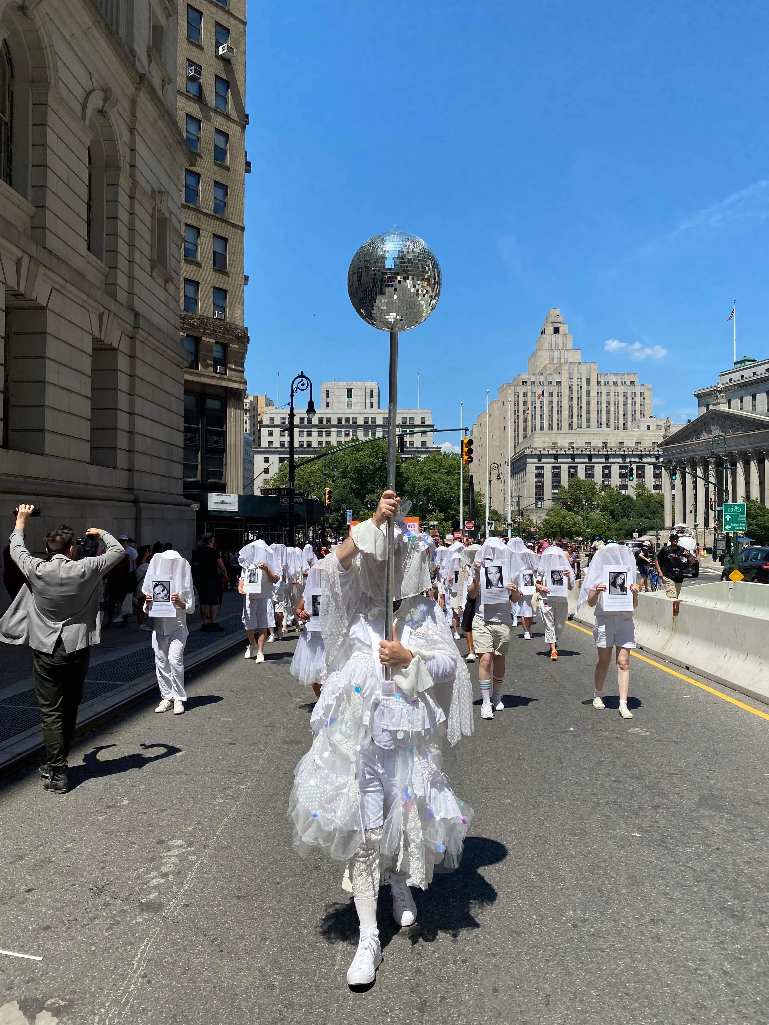 Sylvan carrying disco ball with Gays Against Guns at Queer Liberation March (2022)