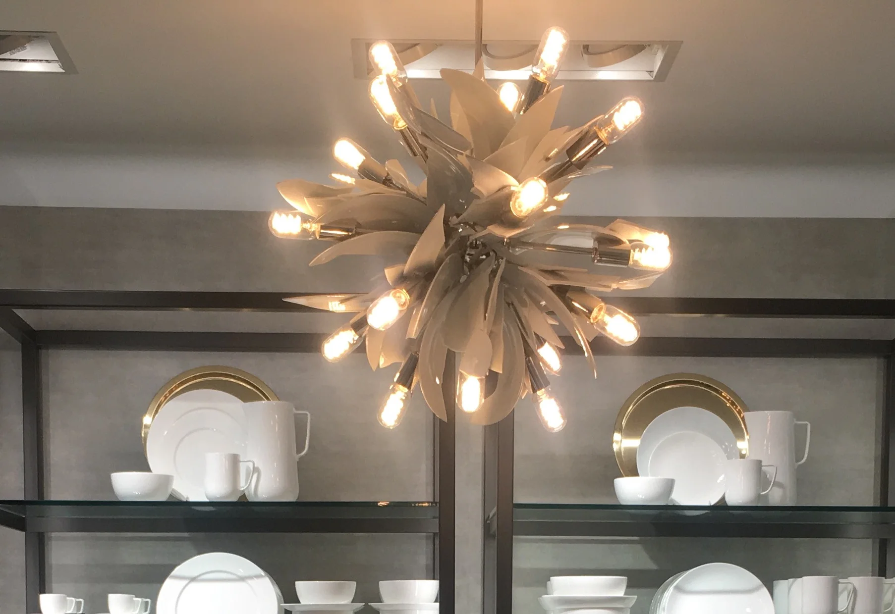 Broken plates artistically sculpted into a glamorous chandelier in a shop where tabletop white dinnerware is sold