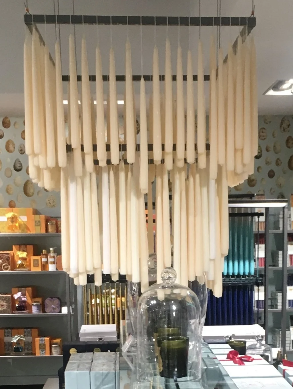 Joined wick candles hang from a custom made ceiling structure in a candle and gift shop