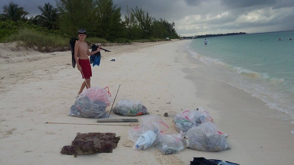 Justin Snisky II surveys the marine  debris collected by the EARTHCARE volunteers.jpg