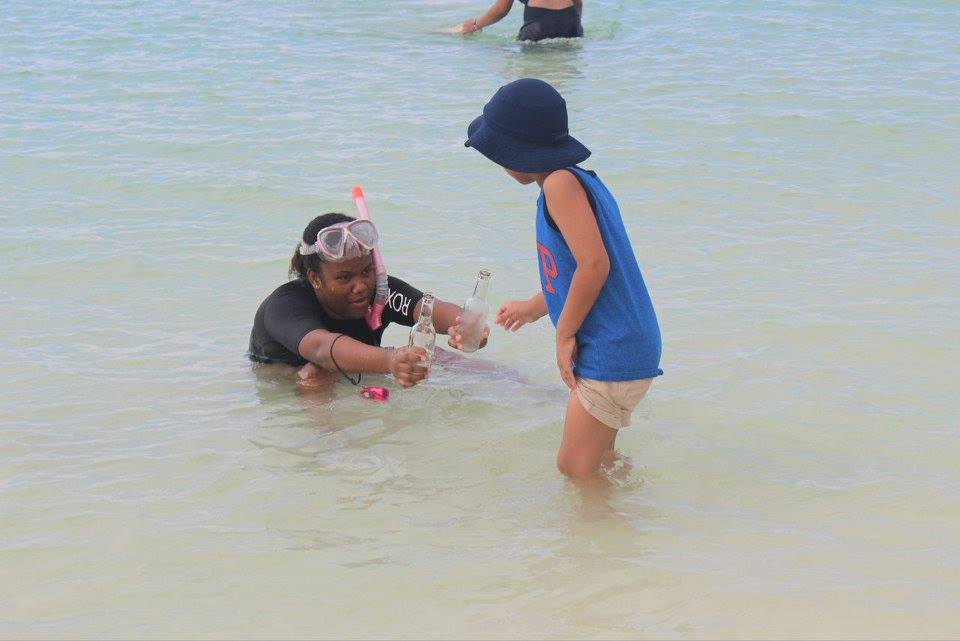 Angelina Rahming, EARTHCARE Eco  Kids Team Leader, hands beverage bottles found underwater to her brother,  Aiden for proper disposal onshore..jpg