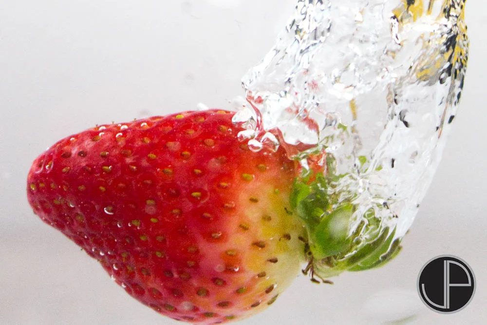 Stopping motion can be a tricky, but interesting, photography project. Dropping objects into water can add some dramatic effect as it adds a trail to the object as well as a cool splash. For this project, I chose a nice ripe strawberry. Read on to s