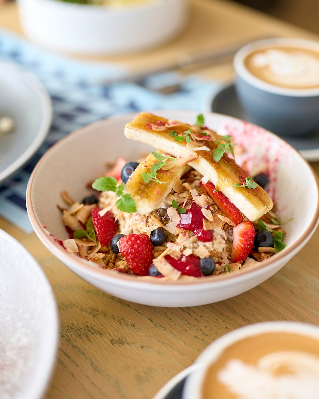 Fresh and fabulous, our vegan Bircher Muesli delivers big-time flavour and texture. With date, sultana &amp; chia oats, coconut labneh, raspberry gel, seasonal fruits, nut crumble, banana br&ucirc;l&eacute;e and coconut crisp &ndash; it really is the