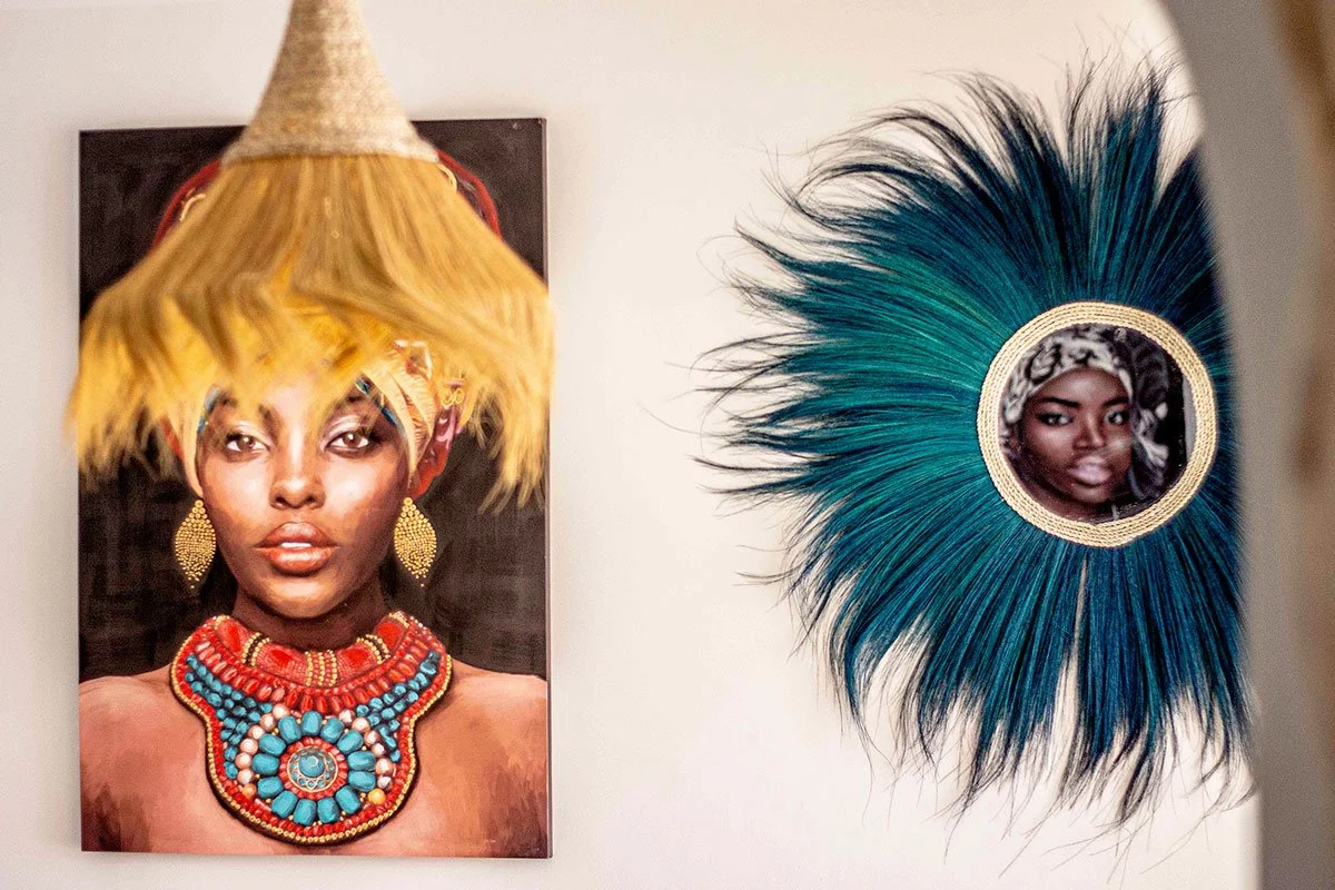 Fotografía de una mujer con accesorios de joyería y un tocado llamativo, junto a un espejo decorativo con el reflejo de otra mujer en el centro
