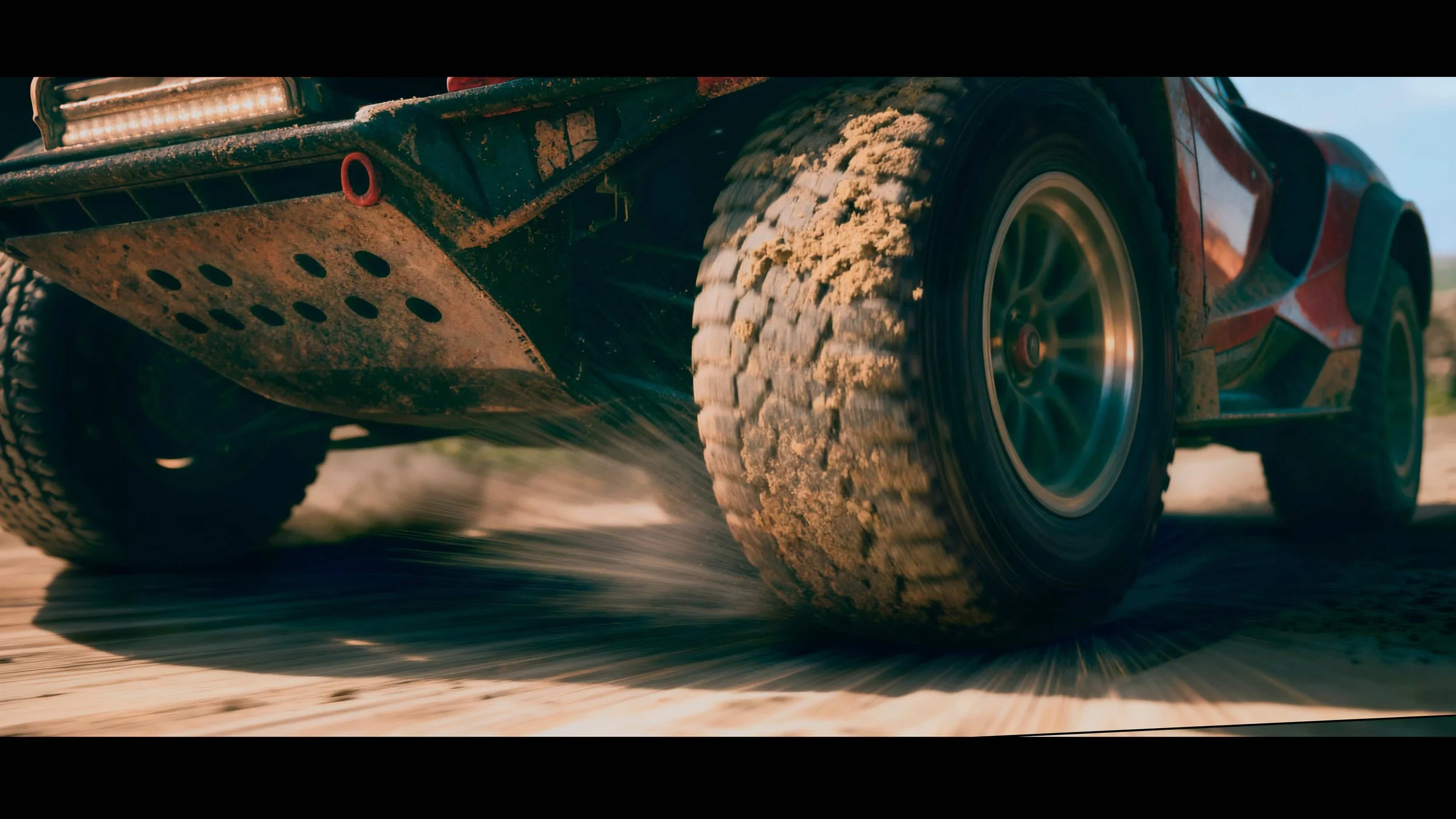 Una vehículo de carreras cruza sobre tierra, levantando polvo y suciedad.