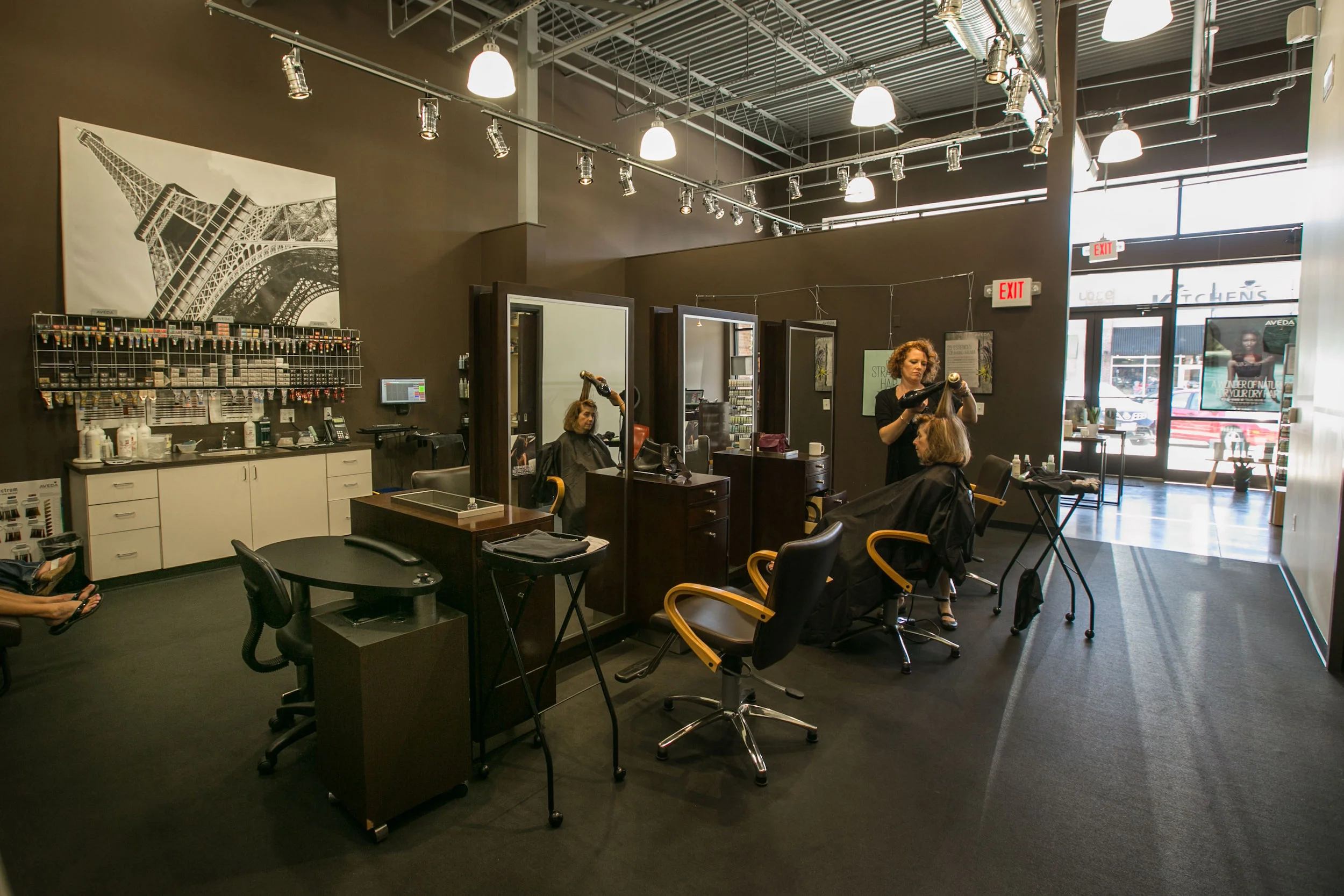 Stylists dress a woman's hair in the remodeled Salon Ami