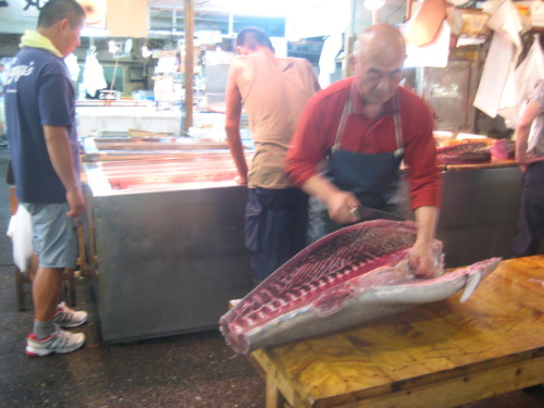 A worker slicing fresh tuna at Tsukiji fish market, Tokyo.