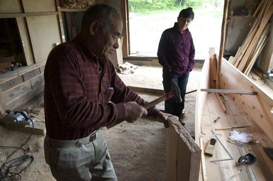Murakami-san working on the boat, with me observing. Photo credit: Douglas Brooks.