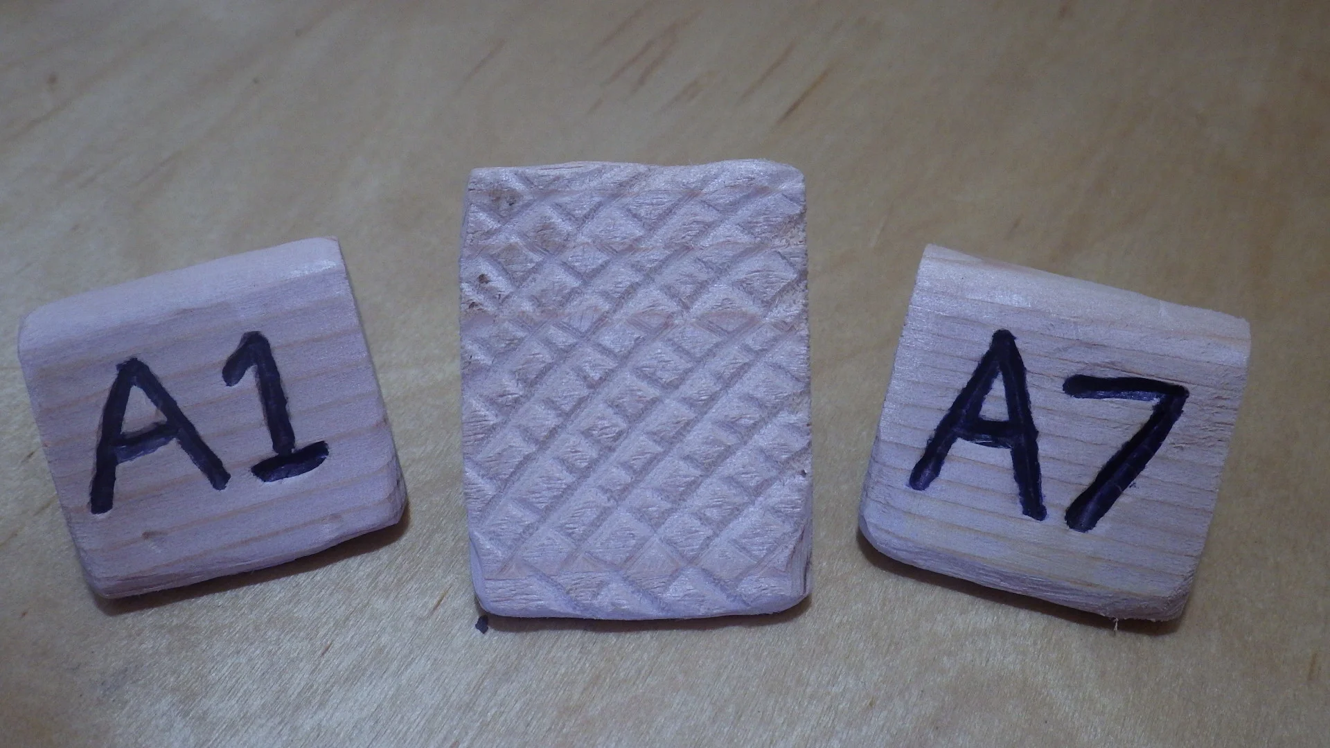 Cedar hat tags showing inset lettering and scoring pattern on bottom