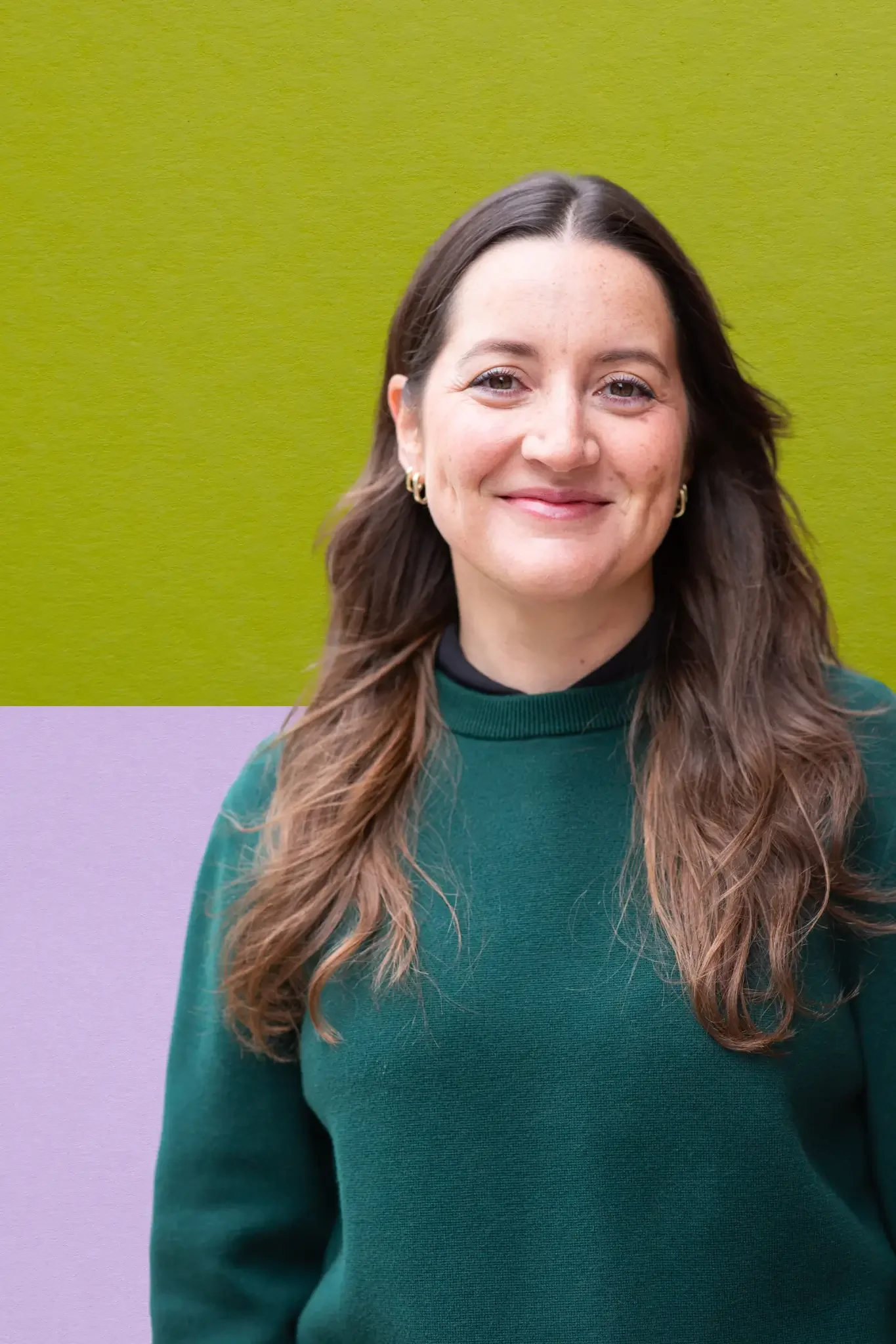 Photo of Mariana Prutton, therapist with long brown hair, wearing a green sweater and gold earrings.