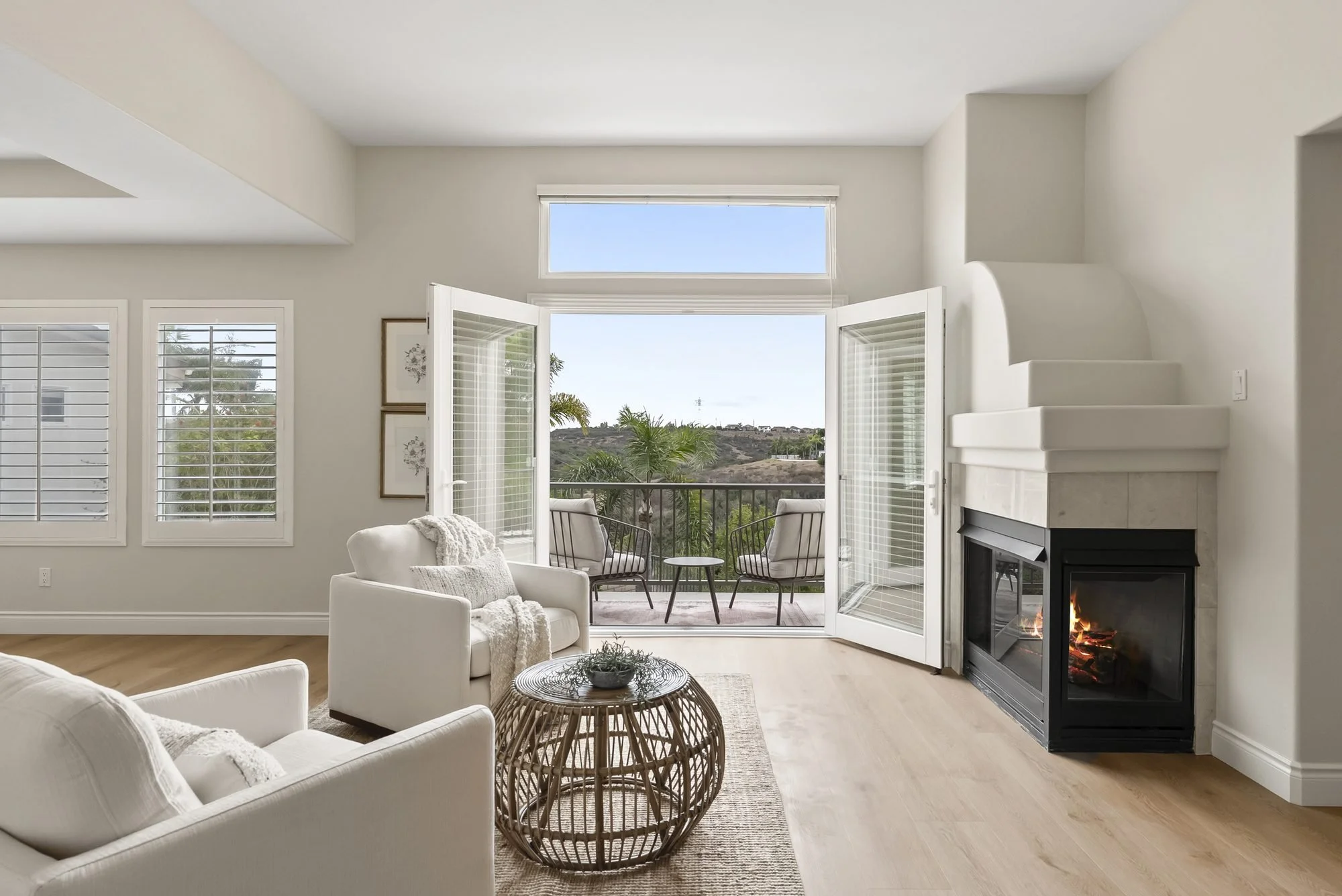 Staged sitting area with fireplace and balcony view at 5439 Harvest Run Dr, a CASA BY CRAFT San Diego staging