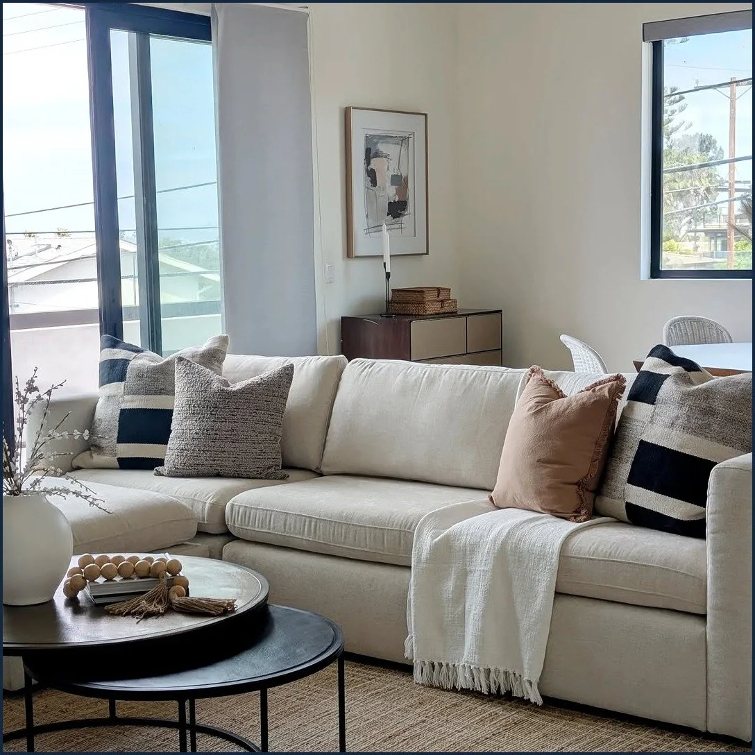 Sunset Cliffs staged living room with a linen sofa, walnut chest and framed abstract art