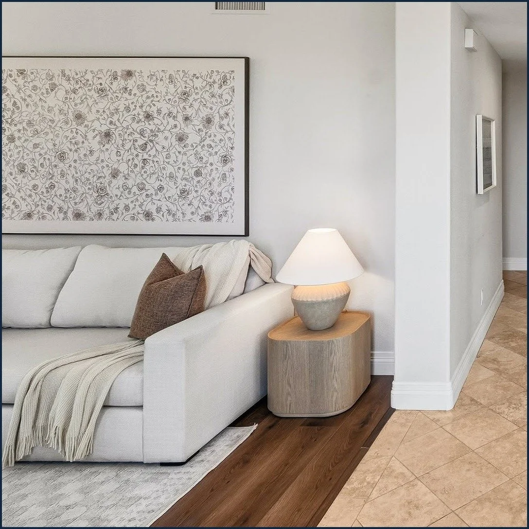 Carlsbad staged living room with a light sofa, large botanical art and a ceramic lamp
