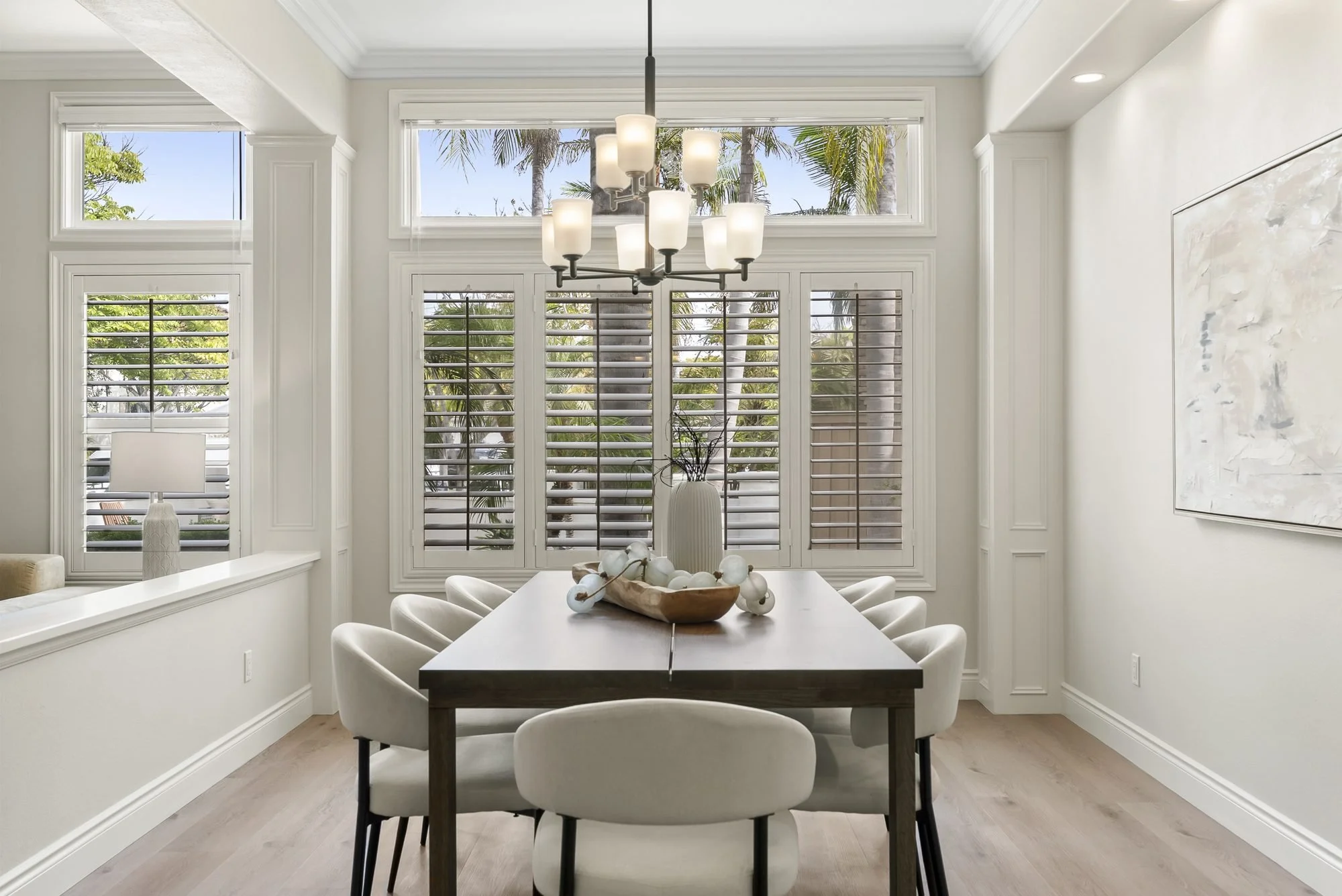Staged dining room with chandelier and plantation shutters at 5439 Harvest Run Dr, San Diego