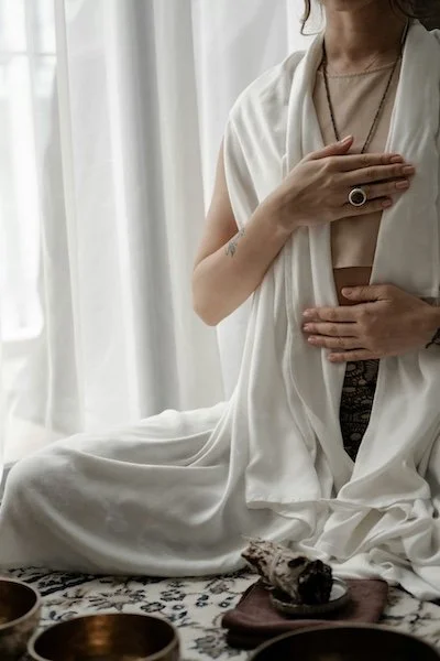 Vrouw met hand op het hart zit in meditatie 