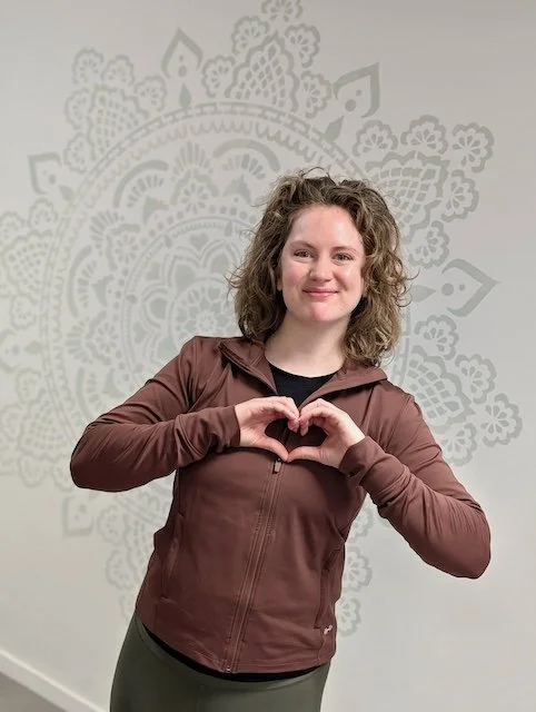 Docente demonstreert een hart voor haar hart uit liefde voor Hatha yoga